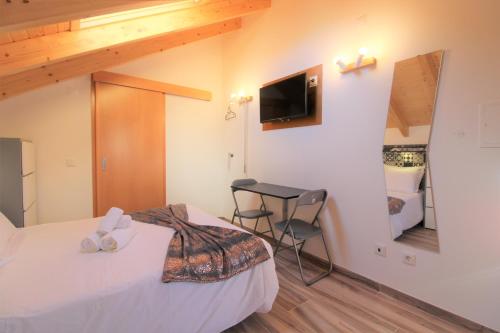 a bedroom with a bed and a table and a mirror at Casa das Rendas by CosyCasa Praia Peniche in Peniche