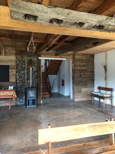 Habitación grande con chimenea y paredes de madera. en Pu Am Eco Lodge, en Curarrehue