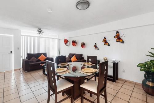 a living room with a table and butterflies on the wall at Encantadora Suite Céntrica Av Tecnológico S8 in Casa Blanca La Corregidora