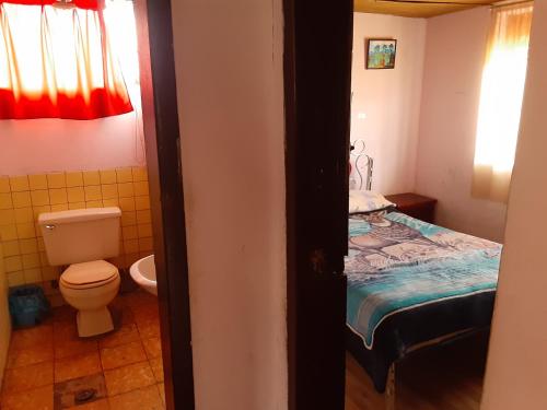 a bathroom with a bed and a toilet in a room at Hospedaje Chimborazo in Chimborazo