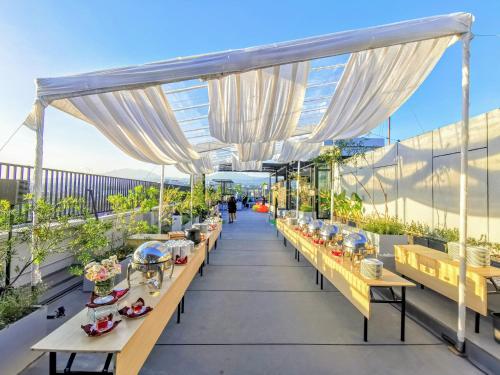 a row of tables on a balcony with white curtains at Zest Sukajadi Bandung by Swiss-Belhotel International in Bandung