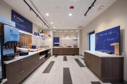 a kitchen with wooden cabinets and a blue sign on the wall at Holiday Inn Express & Suites Chicago - Hoffman Estates, an IHG Hotel in Hoffman Estates