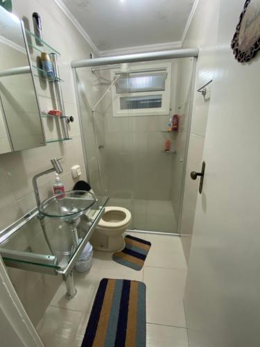 bagno con servizi igienici e lavandino in vetro di Ap 304 - Beira mar - pés na areia a Capão da Canoa