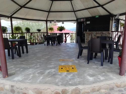 a tent with tables and chairs and a yellow sign on the floor at Payande - Tatacoa in Villavieja