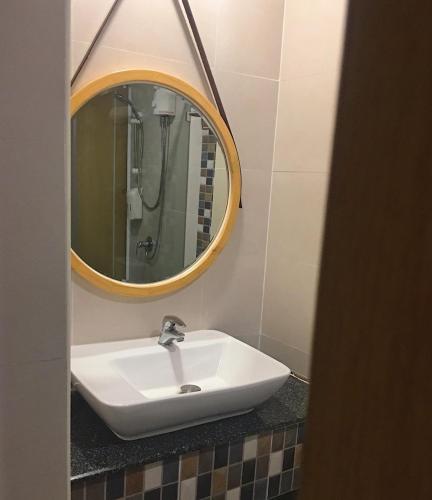 a bathroom with a white sink and a mirror at Ingnaam Hotel in Ban Talat Rangsit