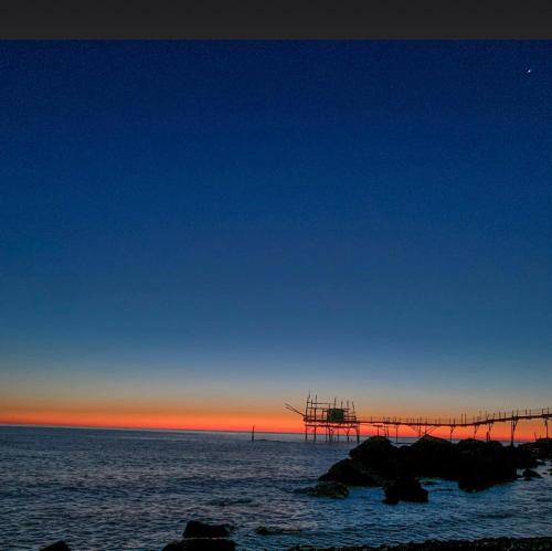 a view of the ocean with a bridge in the water at Agriturismo La Costa dei Trabocchi in Torino di Sangro