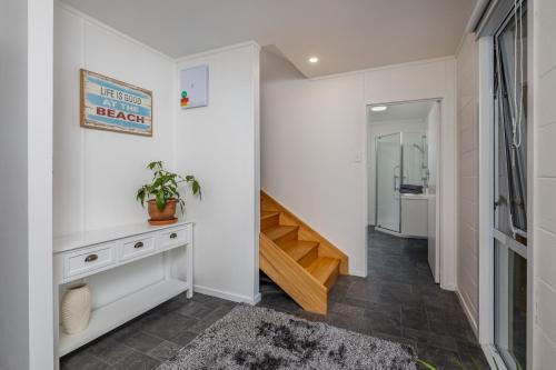 un pasillo con paredes blancas y una escalera en Waterfront Beach House - Paihia Holiday Home en Paihia