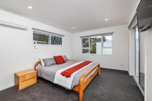 a bedroom with a bed and a flat screen tv at Waterfront Beach House - Paihia Holiday Home in Paihia