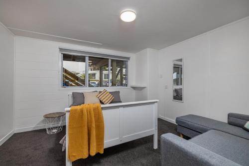 a living room with a couch and a window at Waterfront Beach House - Paihia Holiday Home in Paihia