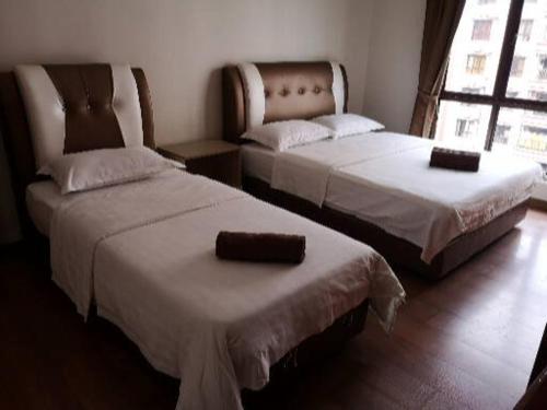 twee bedden naast elkaar in een kamer bij Marina Court Kk City Homestay in Kota Kinabalu