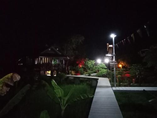 a night view of a house with a street light at เรือนไทยใจสุขเอ๋ย in Ban Bang Wa