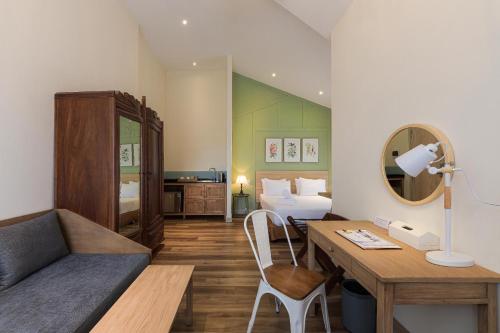 a room with a bed and a desk with a bed and a bed at La Em Boutique Villa in Da Lat