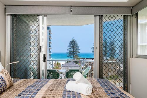 
a hotel room with a bed and a window at Rainbow Bay Resort Holiday Apartments in Gold Coast
