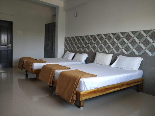 two beds in a hotel room withskirts at Quiet Home in Pondicherry