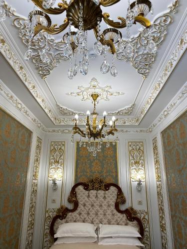 a room with a bed with a chandelier and a ceiling at Lion Hotel in Astana