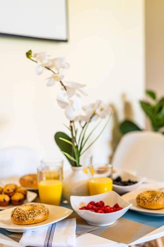 a table topped with plates of breakfast foods and orange juice at Top Floor Ocean Views Condo in Kihei