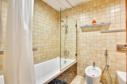 ein Bad mit einer Badewanne, einem WC und einer Dusche in der Unterkunft Perfect studio near the beach JBR in Dubai