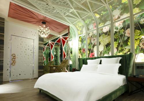 a bedroom with a large bed with a floral wall at Royal Group Motel Jhong Hua Branch in Kaohsiung