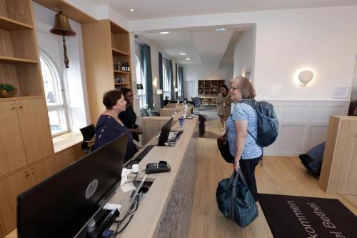a woman standing in a library looking at computers at Hotel Bethel in Copenhagen