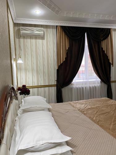 a bed in a bedroom with a window at Lion Hotel in Astana