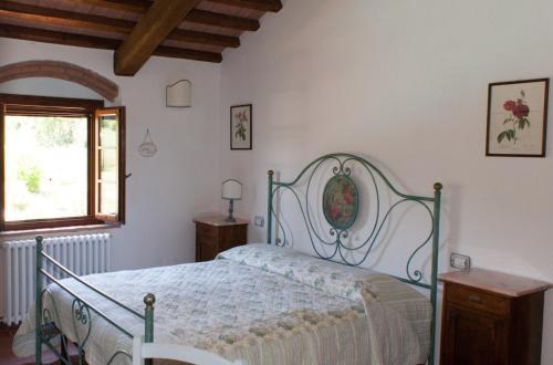 a bedroom with a bed and a window at Podere i Melograni in Guardistallo