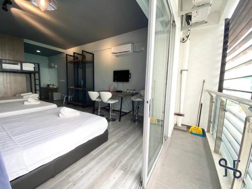 a bedroom with a bed and a table with chairs at Homesuite' Home at Aeropod SOVO in Kota Kinabalu