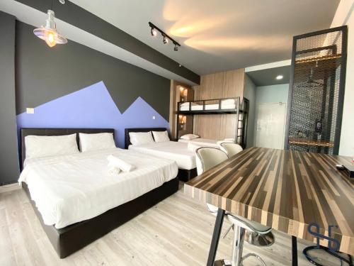 a hotel room with two beds and a table at Homesuite' Home at Aeropod SOVO in Kota Kinabalu
