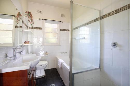 a bathroom with a shower and a toilet and a sink at Rodova Cottage in Katoomba