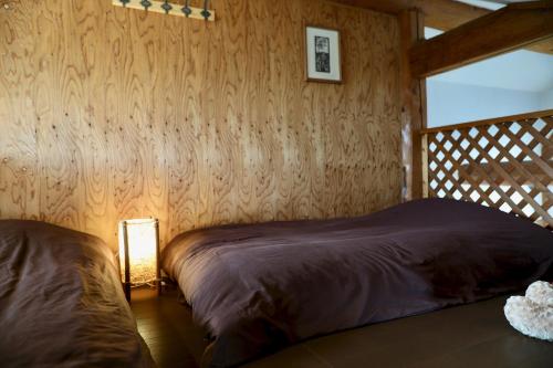 札幌市にあるSapporo Luxury Log House 5Brm max 18ppl 4 free parkingの木製の壁のベッドルーム1室(ベッド1台付)