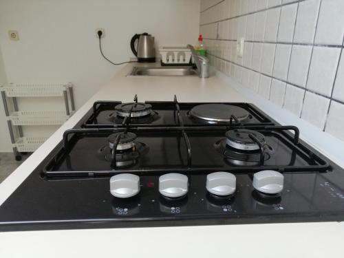 a stove top with four pots and pans on it at Apartman Kopriva in Koprivnica