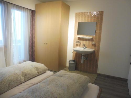 - une chambre avec un lit, un lavabo et un miroir dans l'établissement Apartment Theresli First Floor, à Saas-Almagell