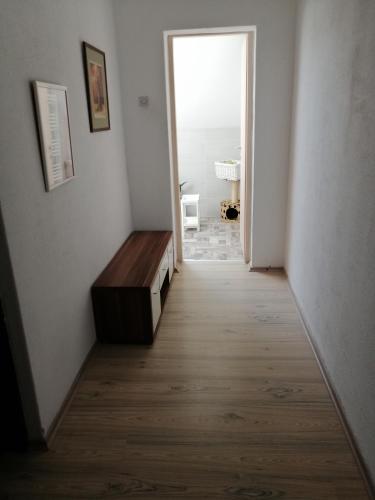 a hallway with a wooden floor and a room with a door at Apartman Kopriva in Koprivnica