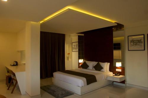 a bedroom with a bed and a desk in a room at Boon Inn in Malappuram