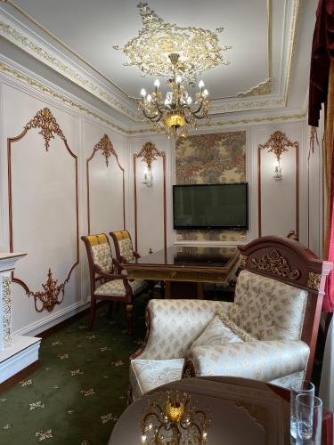 a living room with a table and a chandelier at Lion Hotel in Astana