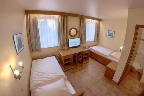 a room with a bed and a desk with a computer at Landhaus Göddertzhof in Erkelenz