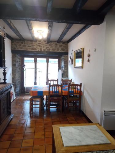 une salle à manger avec une table et des chaises dans l'établissement Maison La Place, à Mérens-lès-Vals