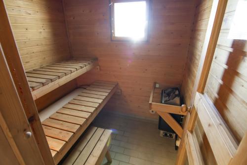 an inside view of a wooden cabin with three bunk beds at Naapurivaaran Lomakeskus in Vuokatti