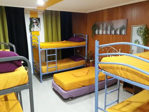 アリカンテにあるHostal Mayorの黄色いシーツが敷かれた二段ベッド3組が備わる客室です。