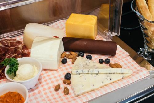 a tray of different types of cheese and other foods at Central Point Hotel Beograd in Belgrade
