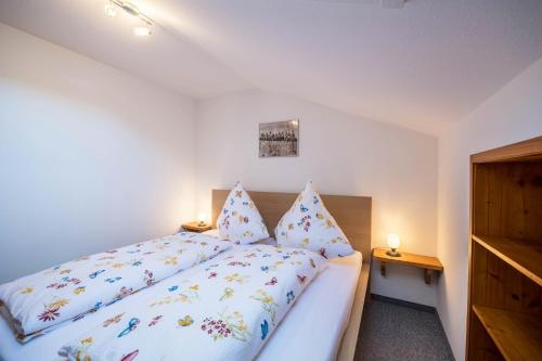 a bedroom with a white bed with pillows at Ferienwohnung Gipfelblick in Grainau