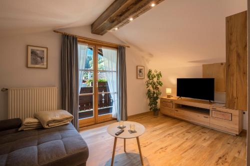a living room with a couch and a tv at Ferienwohnung Gipfelblick in Grainau