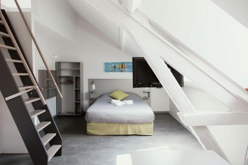 a bedroom with a bed and a staircase at SmartAppart Saint Nazaire in Saint-Nazaire