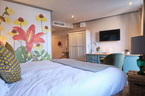 a bedroom with a bed and a desk with a television at Dog and Fox in London