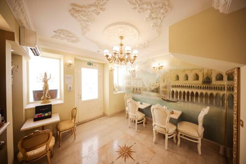 a dining room with chairs and a chandelier at Palazzo Venezia-Adults Only in Zadar