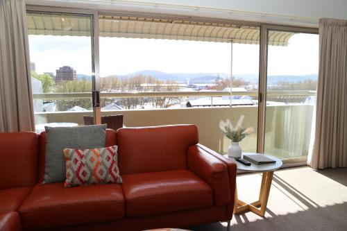 a living room with a couch and a large window at Salamanca Inn in Hobart