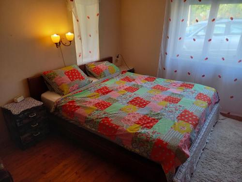 a bedroom with a bed with a quilt on it at Kert Övezeti Lakás in Gyöngyös