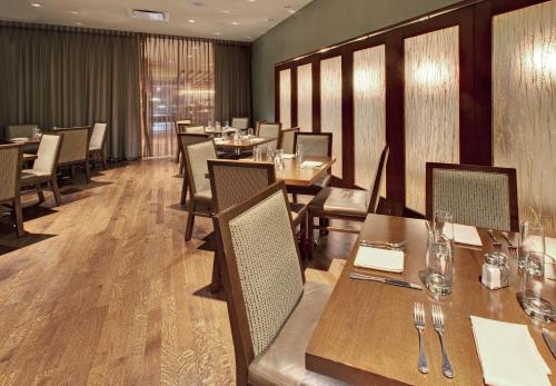 a dining room with wooden tables and chairs at Crowne Plaza Hotel Glen Ellyn/Lombard by IHG in Glen Ellyn