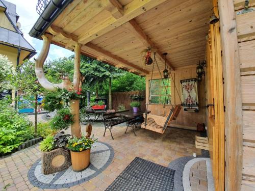 a patio with a wooden pergola and a table at Domek Góralski Chatka Puchatka in Poronin