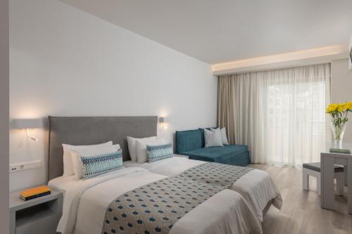 a bedroom with a large bed and a blue chair at Bio Suites Hotel & Spa in Rethymno Town