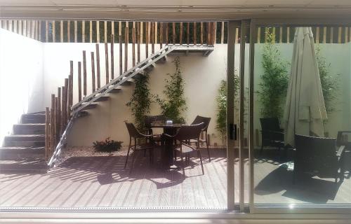 a patio with a table and chairs and a staircase at Equinaturi in Santo Tirso